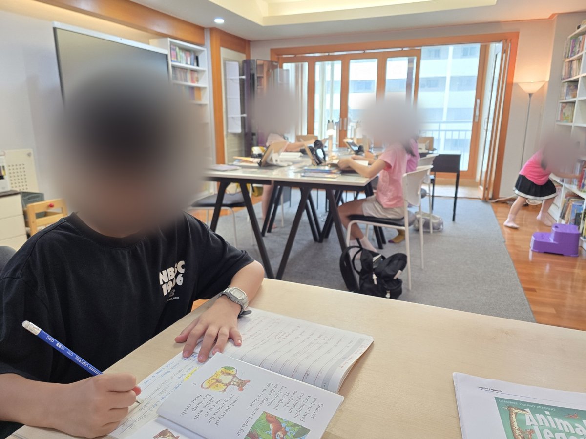 리딩반 수업 풍경: 테이블에서 원서를 읽고 기록하는 아이들